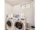 Bright laundry room featuring a washer, dryer, and storage at 12700 E Kentucky Pl, Aurora, CO 80012