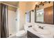 Well-lit bathroom featuring a single sink vanity and a shower with gray curtains at 13661 W Tufts Ave, Morrison, CO 80465