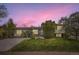 Inviting home at dusk featuring solar panels, lush landscaping, and a well-kept lawn at 13661 W Tufts Ave, Morrison, CO 80465