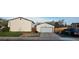 Spacious detached garage with white door and ample parking space alongside a well-kept lawn at 13661 W Tufts Ave, Morrison, CO 80465