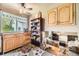Bright kitchen featuring wood cabinets, granite countertops, a ceiling fan, and a view to lower level at 13661 W Tufts Ave, Morrison, CO 80465