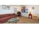 Basement living area with comfortable seating, a glass coffee table, and bright artwork, offering a cozy retreat at 7189 S Kline St, Littleton, CO 80127