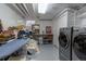 Basement laundry area with modern washer and dryer, ironing station, and ample storage, offering practical convenience at 7189 S Kline St, Littleton, CO 80127