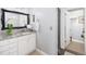 Well-maintained bathroom with granite countertops, framed mirror, and a door leading to a walk in closet at 7189 S Kline St, Littleton, CO 80127