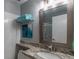 Bathroom with tile floors, vanity with granite countertop, mosaic mirror, and stacked towel bars at 7189 S Kline St, Littleton, CO 80127