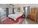 Comfortable bedroom with a ceiling fan, large rug, and a large bed with a red and white valance at 7189 S Kline St, Littleton, CO 80127