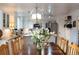 Elegant dining area boasts a hardwood table, chandelier, and an open view of the modern kitchen with stainless steel appliances at 7189 S Kline St, Littleton, CO 80127