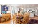 Dining room featuring wood floors and seating for eight, leading into kitchen at 7189 S Kline St, Littleton, CO 80127