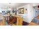 Dining area featuring wood table with seating for eight, view into kitchen and stairway at 7189 S Kline St, Littleton, CO 80127