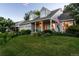 Attractive home featuring a covered porch, two-car garage, well-maintained lawn, and an American flag, showcasing classic charm at 7189 S Kline St, Littleton, CO 80127
