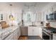 White kitchen featuring stainless steel appliances, granite countertops, subway tile, and modern lighting at 7189 S Kline St, Littleton, CO 80127