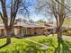 Beautiful backyard with lush green grass, patio, and mature trees providing ample shade at 6314 Brooks Dr, Arvada, CO 80004