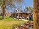Spacious backyard featuring a patio with a dining table, lush lawn, and raised garden beds at 6314 Brooks Dr, Arvada, CO 80004