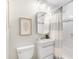 Well-lit bathroom features a toilet, sink, vanity and a shower with tiled wall and curtain at 6314 Brooks Dr, Arvada, CO 80004