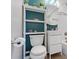 Bathroom featuring a turquoise accent wall, shelving, toilet and vanity at 6314 Brooks Dr, Arvada, CO 80004