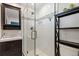 Modern bathroom featuring a glass shower with decorative tile, dark vanity and sleek fixtures at 6314 Brooks Dr, Arvada, CO 80004
