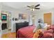 Bright bedroom features a ceiling fan, tv, and doorway to the ensuite bathroom with glass shower door at 6314 Brooks Dr, Arvada, CO 80004