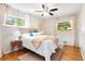 Cozy bedroom featuring hardwood floors, two windows, and light neutral decor at 6314 Brooks Dr, Arvada, CO 80004