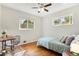 Sunlit bedroom with hardwood floors, two windows, a desk and chair, and ceiling fan at 6314 Brooks Dr, Arvada, CO 80004