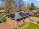 Elevated view of brick home showcasing solar panels and landscaped yard at 6314 Brooks Dr, Arvada, CO 80004