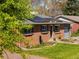 Charming brick home with solar panels, a well-manicured lawn, and mature trees at 6314 Brooks Dr, Arvada, CO 80004