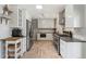Bright, modern kitchen with stainless steel appliances, white cabinets, and herringbone floors at 6314 Brooks Dr, Arvada, CO 80004