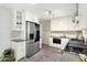 Bright kitchen featuring white cabinets, stainless steel appliances, and herringbone floors at 6314 Brooks Dr, Arvada, CO 80004