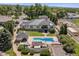 Aerial view features a manicured lawn, swimming pool, and a charming pool house at 13962 W 76Th Ln, Arvada, CO 80005