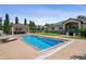 A large pool with an automatic cover and surrounding concrete decking and a view of the back of the house at 13962 W 76Th Ln, Arvada, CO 80005