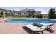 A large pool with surrounding concrete decking and poolside furniture in the backyard at 13962 W 76Th Ln, Arvada, CO 80005
