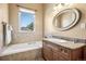 Bathroom features tub with tile surround, granite countertop, and chrome fixtures at 13962 W 76Th Ln, Arvada, CO 80005