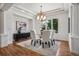 Elegant dining room featuring hardwood floors, a modern chandelier, and a bright window at 13962 W 76Th Ln, Arvada, CO 80005
