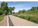 Long driveway to a beautiful field with trees and vegetation and white perimeter fence at 13962 W 76Th Ln, Arvada, CO 80005