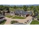 Stunning exterior showcases a landscaped yard, circular driveway, and well-maintained traditional home at 13962 W 76Th Ln, Arvada, CO 80005
