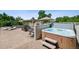 An in-ground hot tub with surrounding concrete decking, poolside furniture, and a shade structure at 13962 W 76Th Ln, Arvada, CO 80005