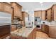 A chef's kitchen with wooden cabinetry, stainless appliances, and granite countertops at 13962 W 76Th Ln, Arvada, CO 80005