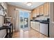 Charming kitchen with wood floors, light cabinets, and sliding door to outdoor patio at 13962 W 76Th Ln, Arvada, CO 80005