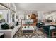 Bright living room with seamless flow to the kitchen, complete with hardwood floors and modern furnishings at 13962 W 76Th Ln, Arvada, CO 80005