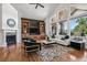 Elegant living room with a fireplace, hardwood floors, built-in cabinets, and views of the outdoors at 13962 W 76Th Ln, Arvada, CO 80005