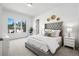 Bright main bedroom features tufted headboard, neutral palette, and large window for natural light at 13962 W 76Th Ln, Arvada, CO 80005