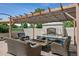 A covered outdoor fireplace with seating and a patio at 13962 W 76Th Ln, Arvada, CO 80005