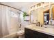 Modern bathroom with a bathtub, toilet, and a vanity with black fixtures and white countertop at 10873 W 84Th Pl, Arvada, CO 80005