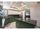 Bright kitchen with green and white cabinetry, stainless steel appliances, and a center island with a cooktop at 10873 W 84Th Pl, Arvada, CO 80005