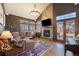 Cozy living room with a stone fireplace, wood flooring, a leather sectional, and access to outdoor space at 10873 W 84Th Pl, Arvada, CO 80005