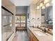 Bathroom with wood cabinets, a gray countertop, a glass enclosed shower and tub, and large window at 434 Kings Crown Rd, Breckenridge, CO 80424