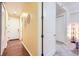 Bright hallway with wood floors, white doors, and neutral wall colors leading to a carpeted bedroom at 2100 N Humboldt St # 207, Denver, CO 80205
