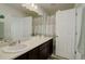 Bathroom with a large mirror over a white sink with dark wood cabinets at 10777 Wheeling Dr, Commerce City, CO 80022