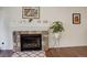 Close-up view of stone fireplace with mantel, decorative accents, and hardwood flooring at 10777 Wheeling Dr, Commerce City, CO 80022