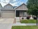 Charming home featuring a well-manicured lawn, inviting front porch, and two-car garage at 10777 Wheeling Dr, Commerce City, CO 80022