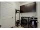 Laundry room with front loading washer and dryer and dark cabinets at 10777 Wheeling Dr, Commerce City, CO 80022